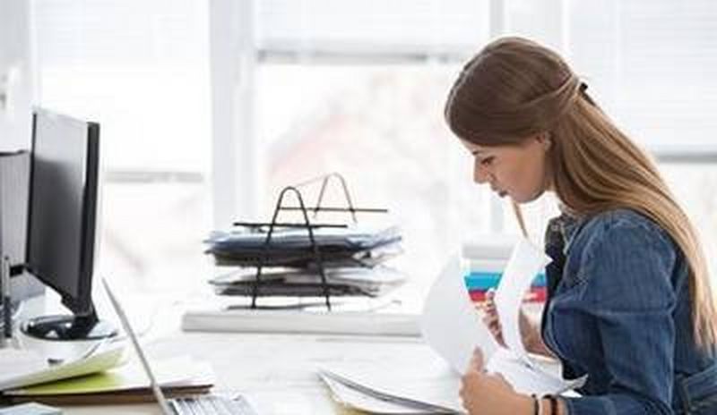 Woman looking through pile of papers